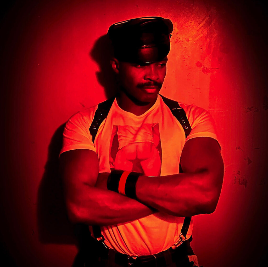 Sexy fetish man wearing a leather wristband with a red stripe on his left arm